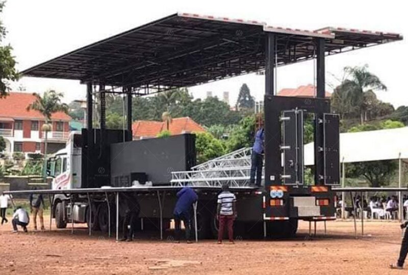 S455 mobile stage semi-trailer in daytime preparation after deployment at the Kampala outdoor venue in Uganda.