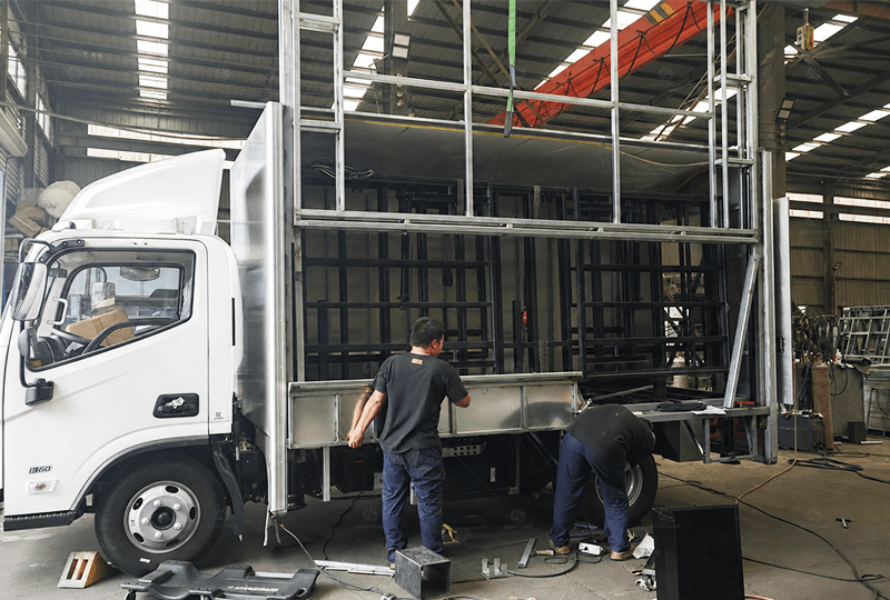 Workers assembling the steel body of a mobile stage truck in the HUAYUAN factory